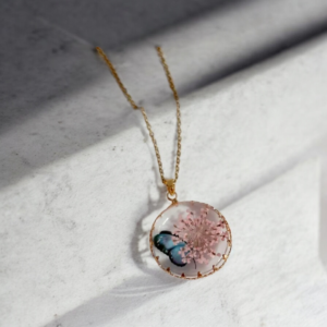 Alternative view of Κολιέ από υγρό γυαλί στρογγυλό με αποξηραμένα λουλούδια ροζ και πεταλούδα