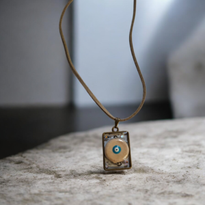Κολιέ από υγρό γυαλί με κεραμικό ματάκι εκρού και σουέτ κορδόνι