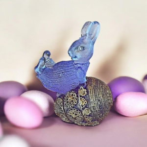 Λαγουδάκι από υγρό γυαλί μωβ ξαπλωμένο σε αυγό